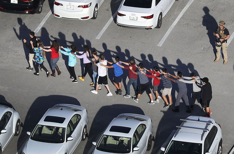 Массовое убийство в американской школе, ученики выходят из здания. Фото: Joe Raedle, Getty