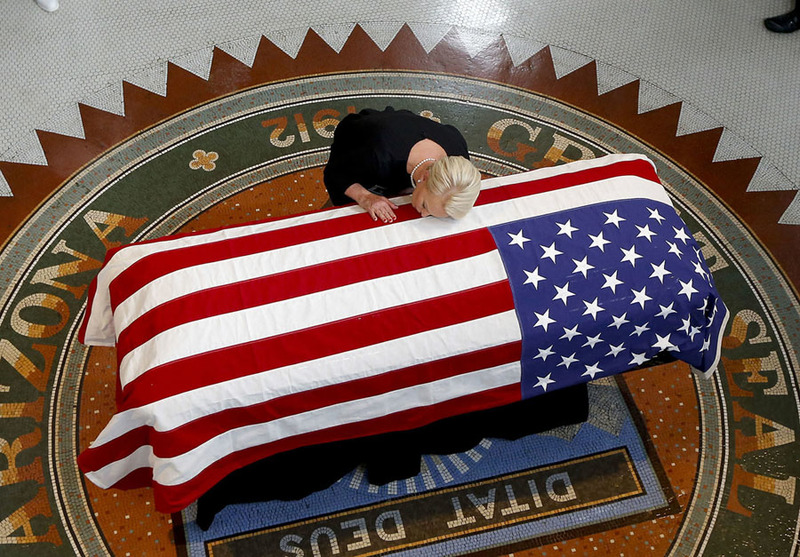 Жена сенатора Джона Маккейна склонила голову над его гробом. Фото: Ross D. Franklin, AP