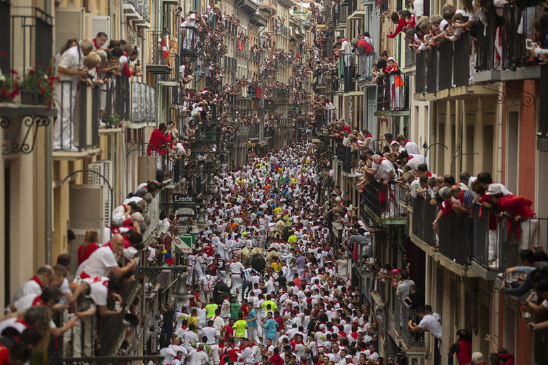 Толпа испанцев бежит от быков по улицам города. Фото: Pablo Blazquez Dominguez, Getty