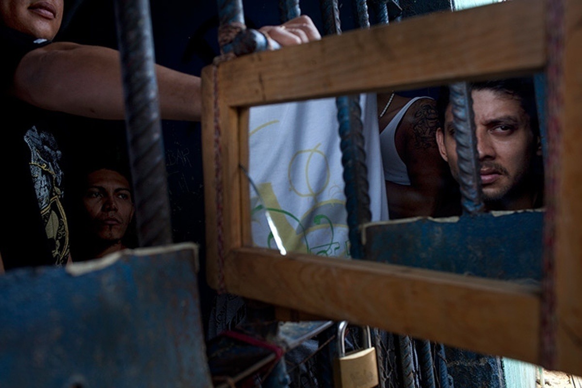 Заключенные при помощи зеркала наблюдают, что происходит за пределами их камеры, Гондурас (2006). Фото: Rodrigo Abd/AP